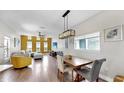 Open-concept living and dining area with modern lighting, hardwood flooring, and contemporary decor at 4002 Carrollwood Palm Ct, Tampa, FL 33624
