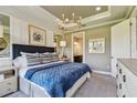 Cozy bedroom showcasing a blue quilted bedspread, decorative pillows, elegant light fixture, and neutral decor at 4257 Rosatti Rd, Wesley Chapel, FL 33543