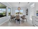 Bright dining room with a modern light fixture, seating for six, and large windows overlooking the water at 4583 Emprise Way, Land O Lakes, FL 34638