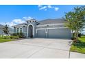 Charming single-Gathering home featuring a two-car garage, lush landscaping and a stylish gray exterior at 5409 Del Coronado Dr, Apollo Beach, FL 33572