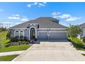 Charming single-Gathering home featuring a two-car garage, lush landscaping and a stylish gray exterior at 5409 Del Coronado Dr, Apollo Beach, FL 33572