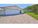 Wide brick-paved driveway leading to a well-kept single-story home with an attached two-car garage at 5785 Bay Pines Lakes Blvd, St Petersburg, FL 33708