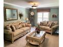 Elegant living room featuring classic furnishings, including sofas, a glass coffee table, and a decorative mirror at 5920 30Th S Ct, St Petersburg, FL 33712
