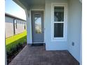 Inviting entryway with decorative glass door and stylish brick paver walkway at 5981 Shorebird Br, Land O Lakes, FL 34638