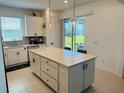 White kitchen island with a breakfast bar, stainless steel appliances, and quartz countertops at 5981 Shorebird Br, Land O Lakes, FL 34638