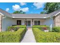 Inviting front porch with elegant columns, lush greenery, and stylish decor that enhances the home's curb appeal at 7414 Mint Julep Dr, Riverview, FL 33578