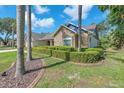 Beautifully landscaped front yard featuring mature palm trees, lush green lawn, and a well-maintained exterior at 7414 Mint Julep Dr, Riverview, FL 33578