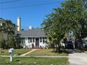 Inviting home with manicured lawn, mature trees, and a driveway leading to backyard at 766 Bay Esplanade, Clearwater Beach, FL 33767