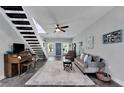 Open-concept living room with a modern staircase, piano, stylish furniture, and a bright front door at 9019 S County Line Rd, Lithia, FL 33547
