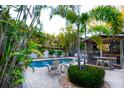 Inviting backyard retreat with a screened lanai, pool, and lush tropical landscaping at 1208 Bay Pine Blvd, Indian Rocks Beach, FL 33785