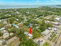 Aerial view shows the property situated near the coast in a community with mature trees at 121 Pennsylvania Ave, Palm Harbor, FL 34683