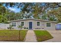 Inviting single-story home with a blue front door, manicured lawn, and a neatly paved walkway at 121 Pennsylvania Ave, Palm Harbor, FL 34683