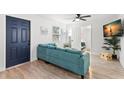 Bright living room featuring a comfortable blue sofa, white walls, and modern wood-look flooring at 121 Pennsylvania Ave, Palm Harbor, FL 34683