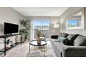 Living room featuring sliding glass doors to balcony, gray sofa and chair, wood-look flooring at 1400 Gandy N Blvd # 1701, St Petersburg, FL 33702