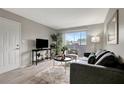 Living room featuring door, sliding glass doors to balcony, gray sofa and chair, wood-look flooring at 1400 Gandy N Blvd # 1701, St Petersburg, FL 33702
