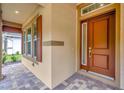Close up of home's inviting entry with red wood door and surrounding desert color walls at 14174 Thoroughbred Dr, Dade City, FL 33525
