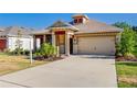 Beautiful home exterior with desert landscaping, a wide driveway, and a two-car garage at 14174 Thoroughbred Dr, Dade City, FL 33525