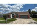 Well-maintained single-story home with a paved driveway, two-car garage, and lush landscaping at 14334 Teasdale Ave, Hudson, FL 34667