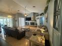 Well-lit living room with a fireplace, ceiling fan, comfortable seating, and access to the screened-in patio at 14334 Teasdale Ave, Hudson, FL 34667