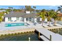 A waterfront home with a modern pool, dock, and seating area with bay view at 1493 Sea Gull S Dr, St Petersburg, FL 33707