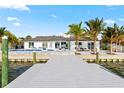 A waterfront home features a modern pool, dock, and outdoor seating with bay view at 1493 Sea Gull S Dr, St Petersburg, FL 33707