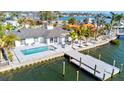 Aerial view of updated waterfront home with modern pool, patio, and private dock on a sunny day at 1493 Sea Gull S Dr, St Petersburg, FL 33707