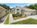 Charming home featuring a two-car garage, lovely landscaping and a manicured lawn at 19232 Barred Owl Ct, Land O Lakes, FL 34638