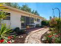 A cozy outdoor seating area with a patio surrounded by lush landscaping and a charming stone pathway at 2200 Marshall Dr, Dunedin, FL 34698