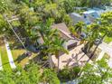 Aerial view of a home surrounded by lush greenery and palm trees, offering a serene and private setting at 2966 Longbrooke Way, Clearwater, FL 33760