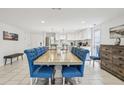 Open dining area with a large table, stylish blue chairs, and direct access to the kitchen at 4902 Blue Heron Dr, New Port Richey, FL 34652
