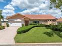 Well-maintained single-story home with a lush green lawn and brick driveway at 4973 60Th S Ave, St Petersburg, FL 33715