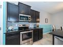 Close up of the kitchen featuring stainless steel appliances and stylish tile backsplash at 7869 Timberview Loop, Wesley Chapel, FL 33545