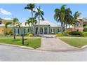 Charming green house with a metal roof, lush landscaping, a brick driveway, and a welcoming front entrance at 819 Islebay Dr, Apollo Beach, FL 33572