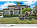 Stunning two-story home featuring a beautiful terra cotta tile roof, lush landscaping, and an inviting facade at 8420 Dunham Station Dr, Tampa, FL 33647