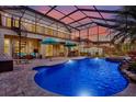 Enjoy this screened pool with spa, paver deck, outdoor seating, and views of the lush backyard at 8420 Dunham Station Dr, Tampa, FL 33647