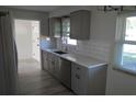 Bright kitchen featuring a stainless steel sink, updated cabinets, subway tile backsplash, and wood-look floors at 9093 108Th St, Seminole, FL 33772