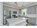 Modern kitchen featuring grey cabinets, stainless appliances, and a large center island at 9754 Redwood Heights Loop, Thonotosassa, FL 33592