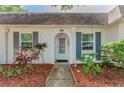 Close-up of front door showing a well-kept entryway with decorative mulch beds and painted window shutters at 4252 Sheldon Pl # 4252, New Port Richey, FL 34652