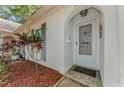 Close up of the front door featuring an arched entry with stylish mulch beds and decorative shutters at 4252 Sheldon Pl # 4252, New Port Richey, FL 34652