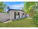 Bright single-story home with a manicured lawn, white fence, and dark window shutters at 12116 N 52Nd St, Temple Terrace, FL 33617