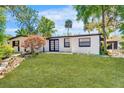 Well-maintained single-story home with a neatly manicured front yard and black trim at 12116 N 52Nd St, Temple Terrace, FL 33617