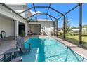Inviting screened-in pool area featuring a refreshing pool with lounge chairs and outdoor patio space at 12546 Wildebeest Way, Spring Hill, FL 34610