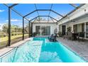 Refreshing screened-in pool area with lounge chairs, dining set, and lush backyard scenery at 12546 Wildebeest Way, Spring Hill, FL 34610