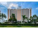 Exterior shot of a high rise building with multiple balconies and beautifully landscaped grounds at 1270 Gulf Blvd # 501, Clearwater Beach, FL 33767