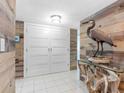 Entryway featuring wood-paneled walls, white doors, tile flooring, and decorative heron sculpture at 1430 Gulf Blvd # 102, Clearwater Beach, FL 33767