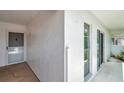 Condo building exterior featuring the front door and sliding glass doors along a walkway at 1655 S Highland Ave # D140, Clearwater, FL 33756