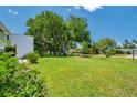 Wide shot of the grassy yard and shady trees behind the condo building exterior at 1655 S Highland Ave # D140, Clearwater, FL 33756
