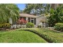 Beautiful home exterior highlighting the manicured lawn and lush tropical landscaping at 250 Aberdeen St, Dunedin, FL 34698