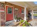 Charming front entry featuring a red door, brick facade and stone accent planters at 3309 W Ellicott St, Tampa, FL 33614