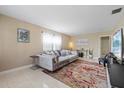 Bright living room showcasing a plush sofa, tile flooring, and neutral wall paint at 3309 W Ellicott St, Tampa, FL 33614